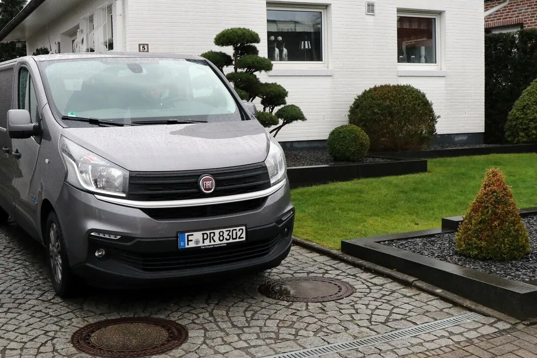 Frontansicht des silbernen Fiat Talento Kastenwagen SX in einer Einfahrt neben einem Haus parkend.